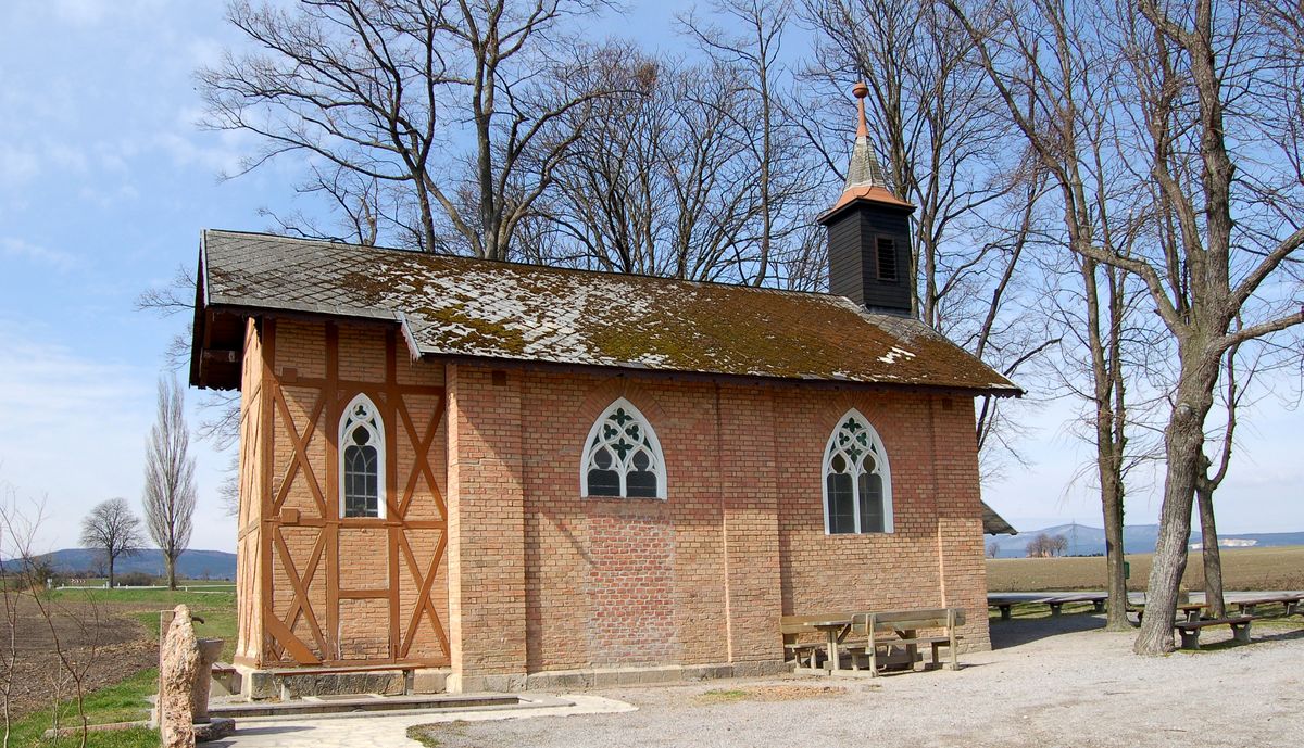 Die Kapelle am Heilsamen Brunnen bei Leobersdorf: Riegelbau mit Ziegelmauerwerk, gotischen Fenstern und kleinem Glockenturm unter kahlen Bäumen